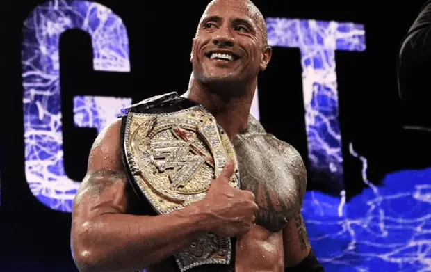 The Rock, o primeiro negro a ser campeão na WWE, com o título.
